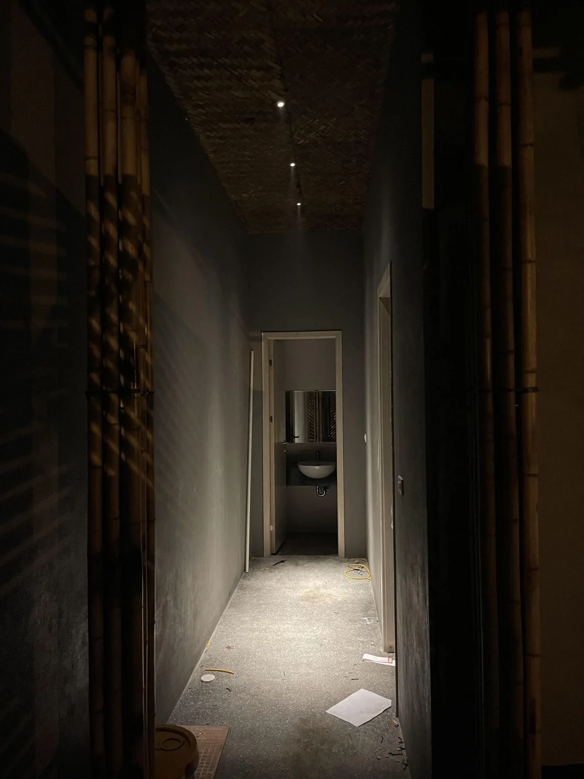 A bamboo corridor leading to a point of light at its end