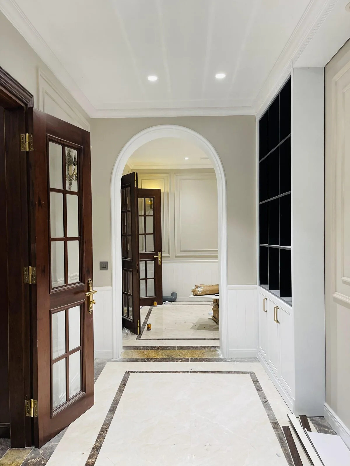 An arched passage into the interior, stone-clad and softly lit