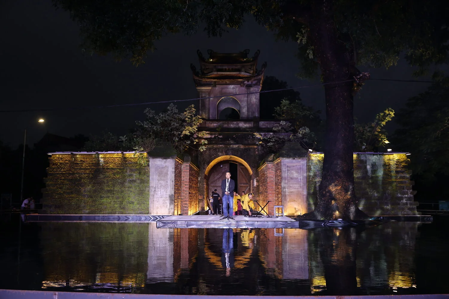 The illuminated gate of Vinh Citadel reflected in the water