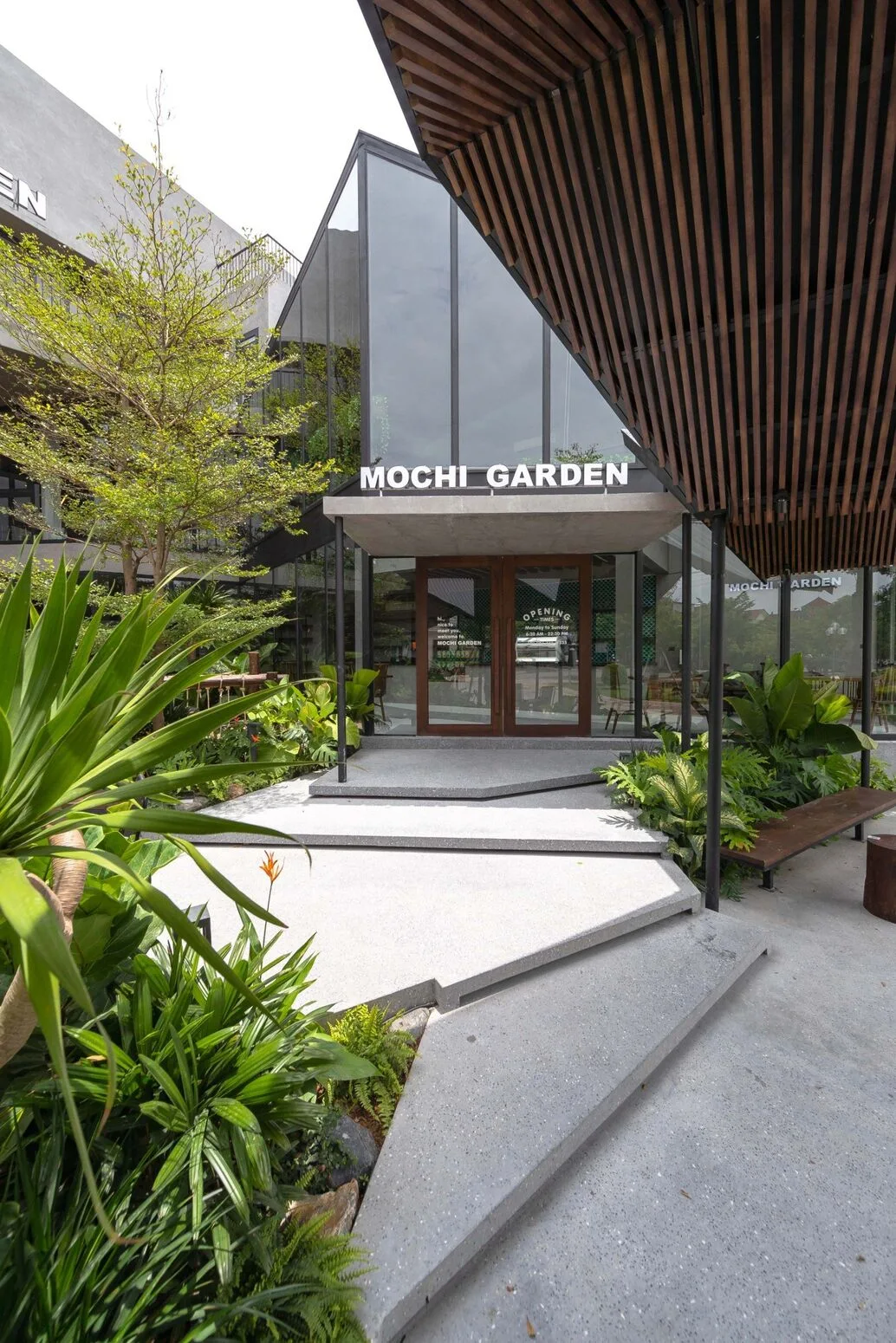 Main entrance with signage and ornamental plants