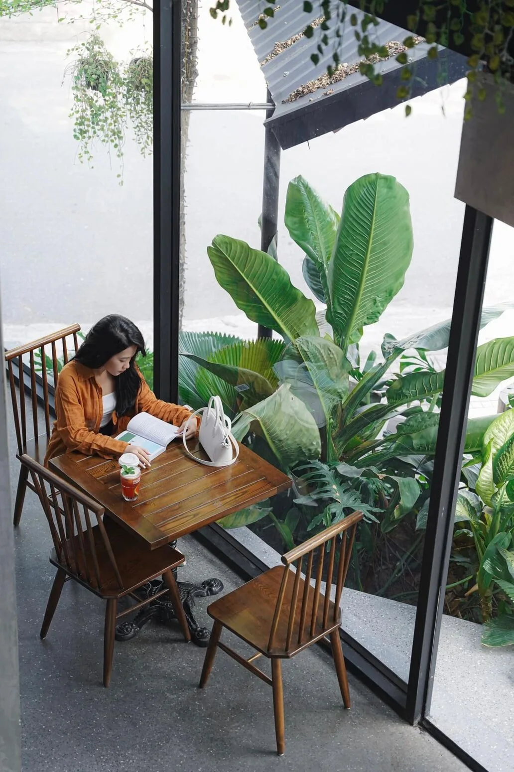A guest at the tea table — soft light enhancing the timber space