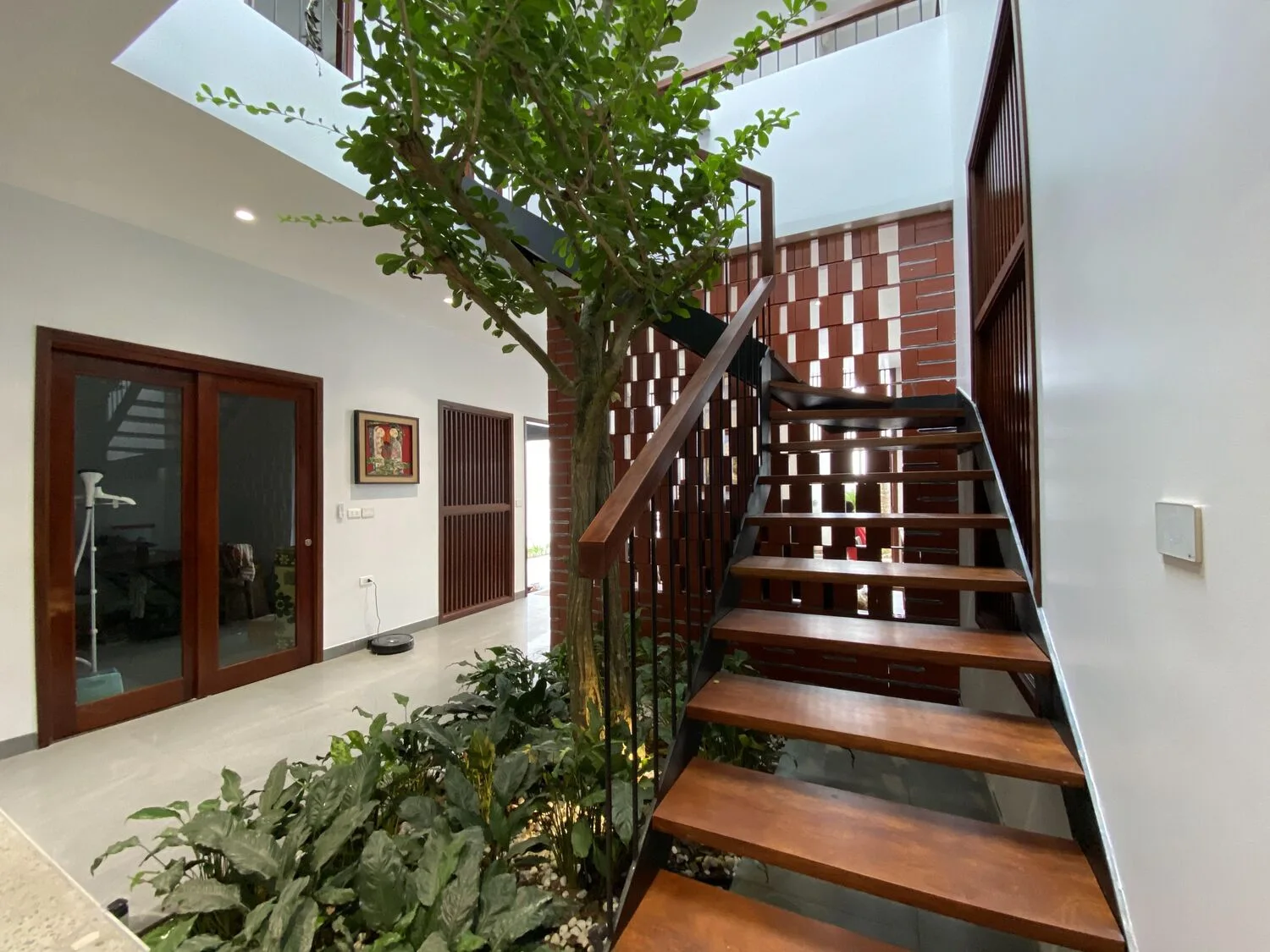 The wooden staircase wrapping the tree at the centre of the house