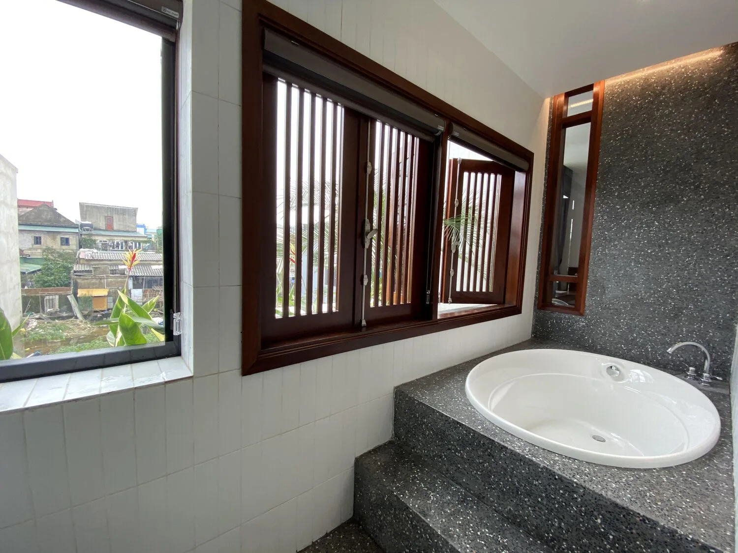A bathroom with a stone tub by the window