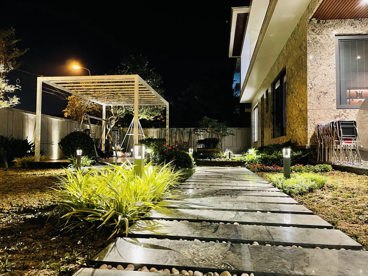 The garden at night — pergola and trees uplit