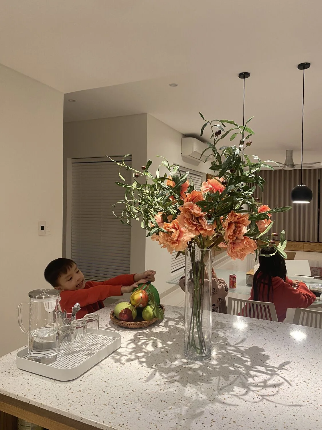 A meal at the dining table, warm light and fresh flowers