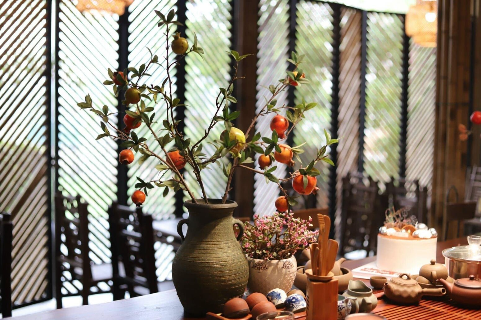 Bình hoa và bàn tiệc bên vách tre