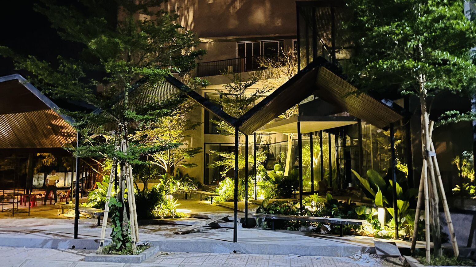 Khối nhà kính lên đèn lúc hoàng hôn giữa vườn cây