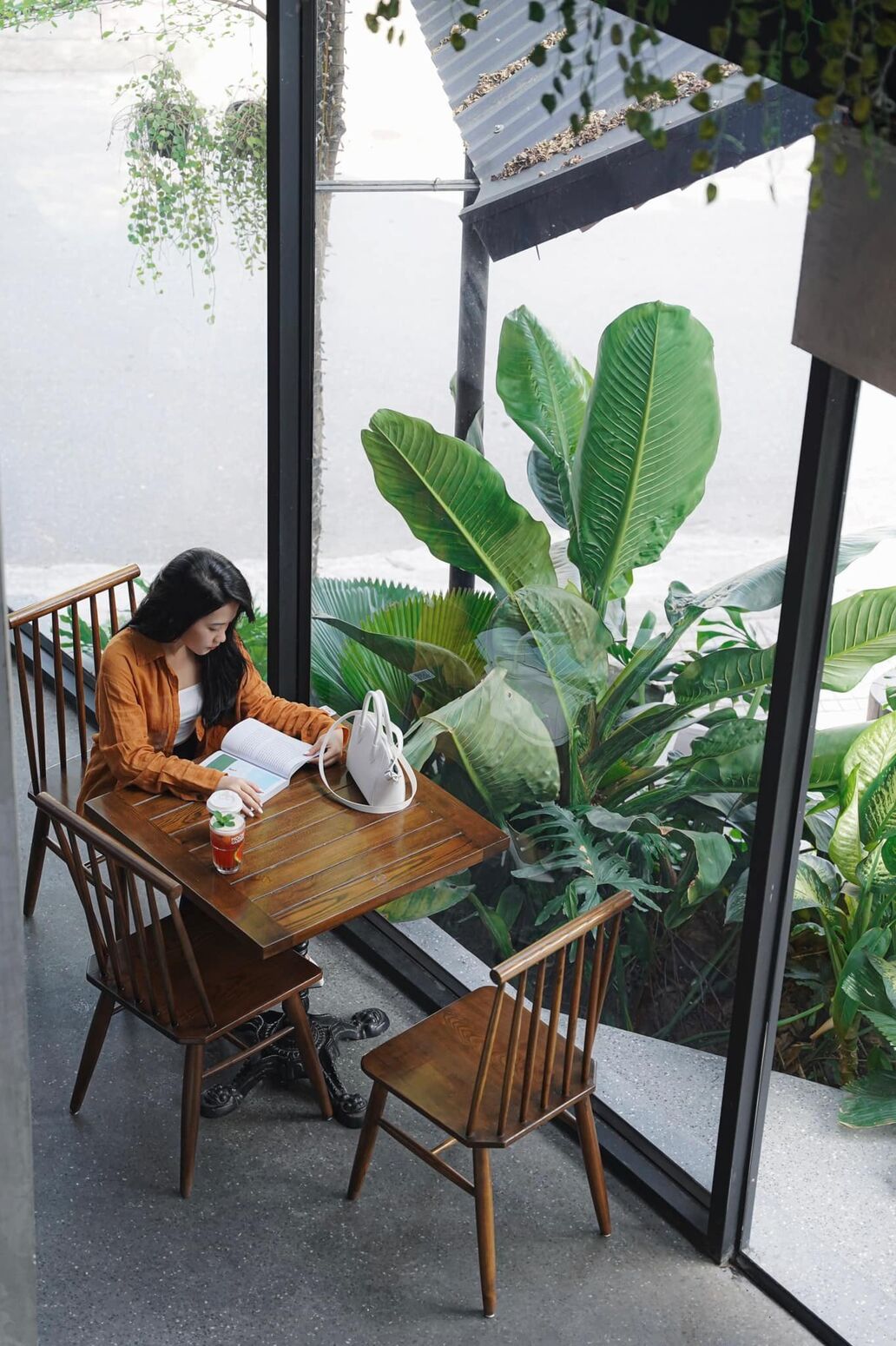 Một vị khách bên bàn trà — ánh sáng dịu tôn không gian gỗ