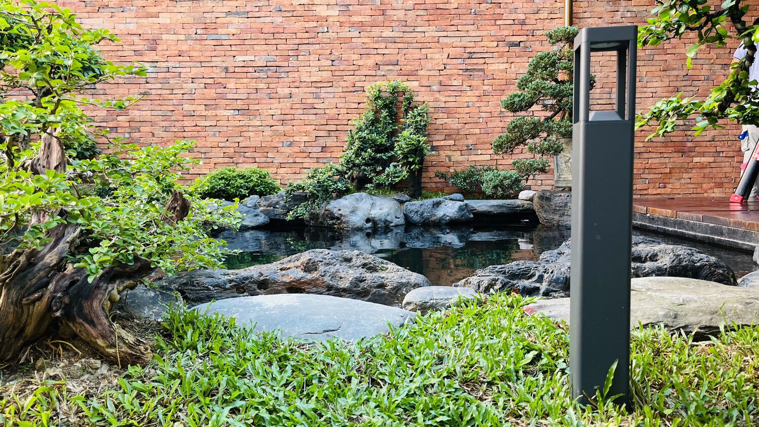 Sân vườn với đèn nấm và bonsai bên hồ