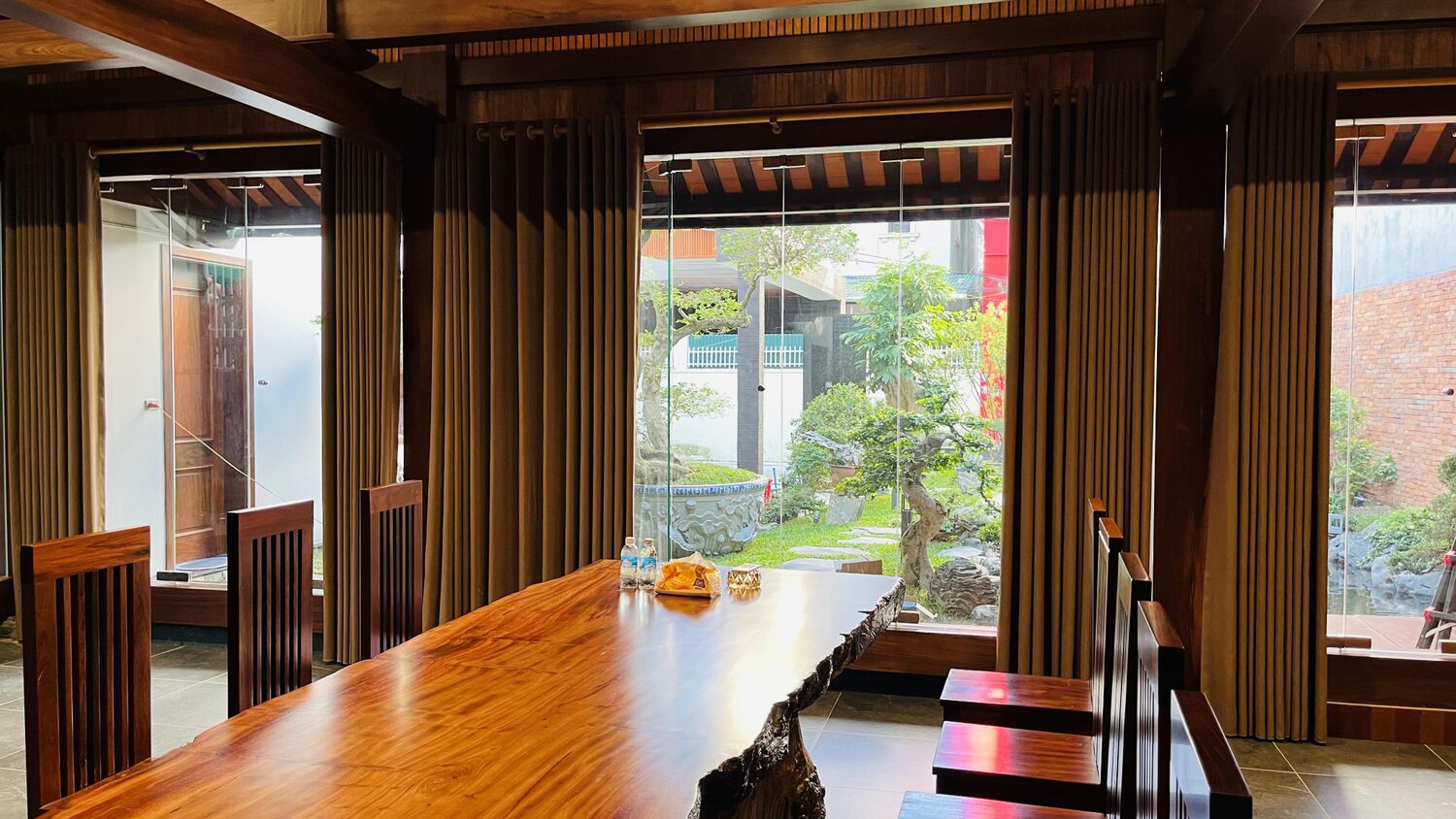 Bàn trà gỗ bên khung cửa nhìn ra vườn